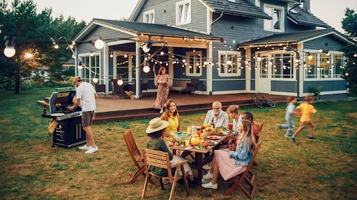 Backyard summer party with safe outdoor electrical setup including lights, grill, and power cord